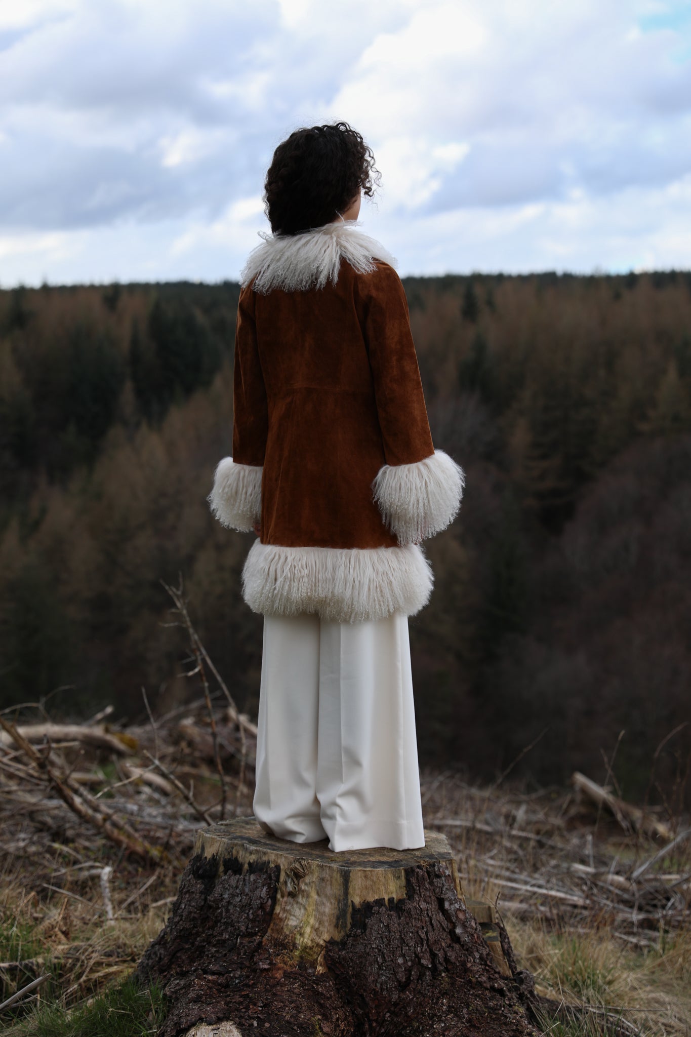 Tan genuine suede afghan penny lane coat mid-length with crew neck, adorned with luxurious ivory Mongolian fur trims by Josephine Jones - exquisite outerwear for timeless style.