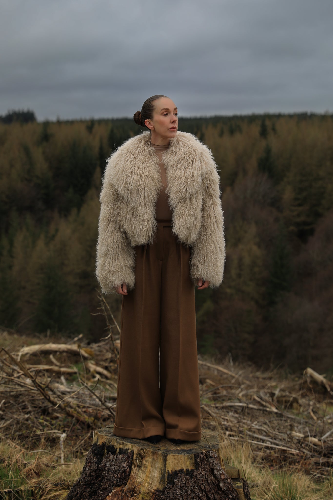 A  timeless beige Mongolian fur coat with a voluminous collar, a classic staple piece from Josephine Jones, exuding elegance and sophistication.