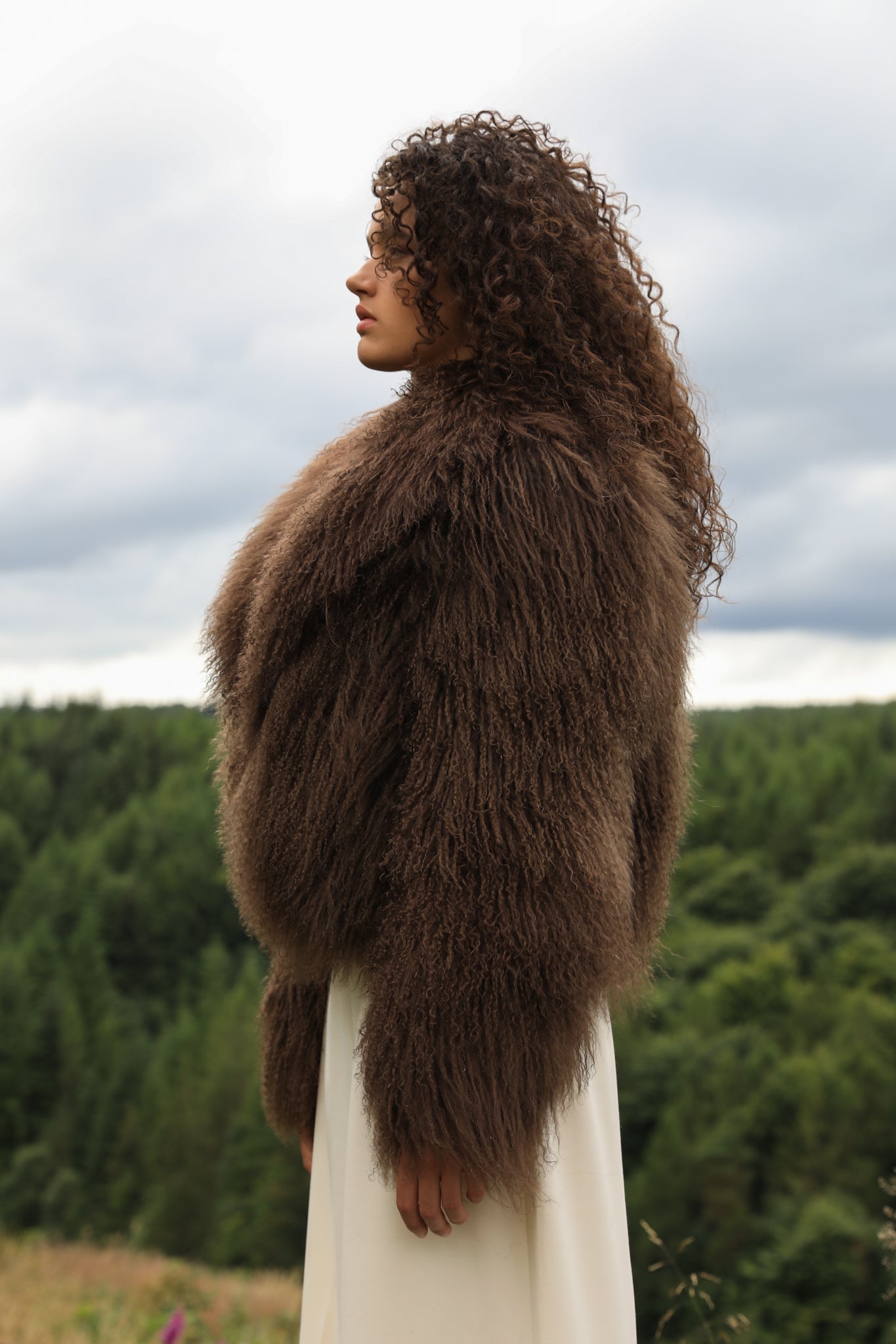 Josephine Jones' signature chocolate-colored Mongolian fur coat, featuring a voluminous collar. A luxurious staple piece perfect for adding warmth and elegance to any ensemble.