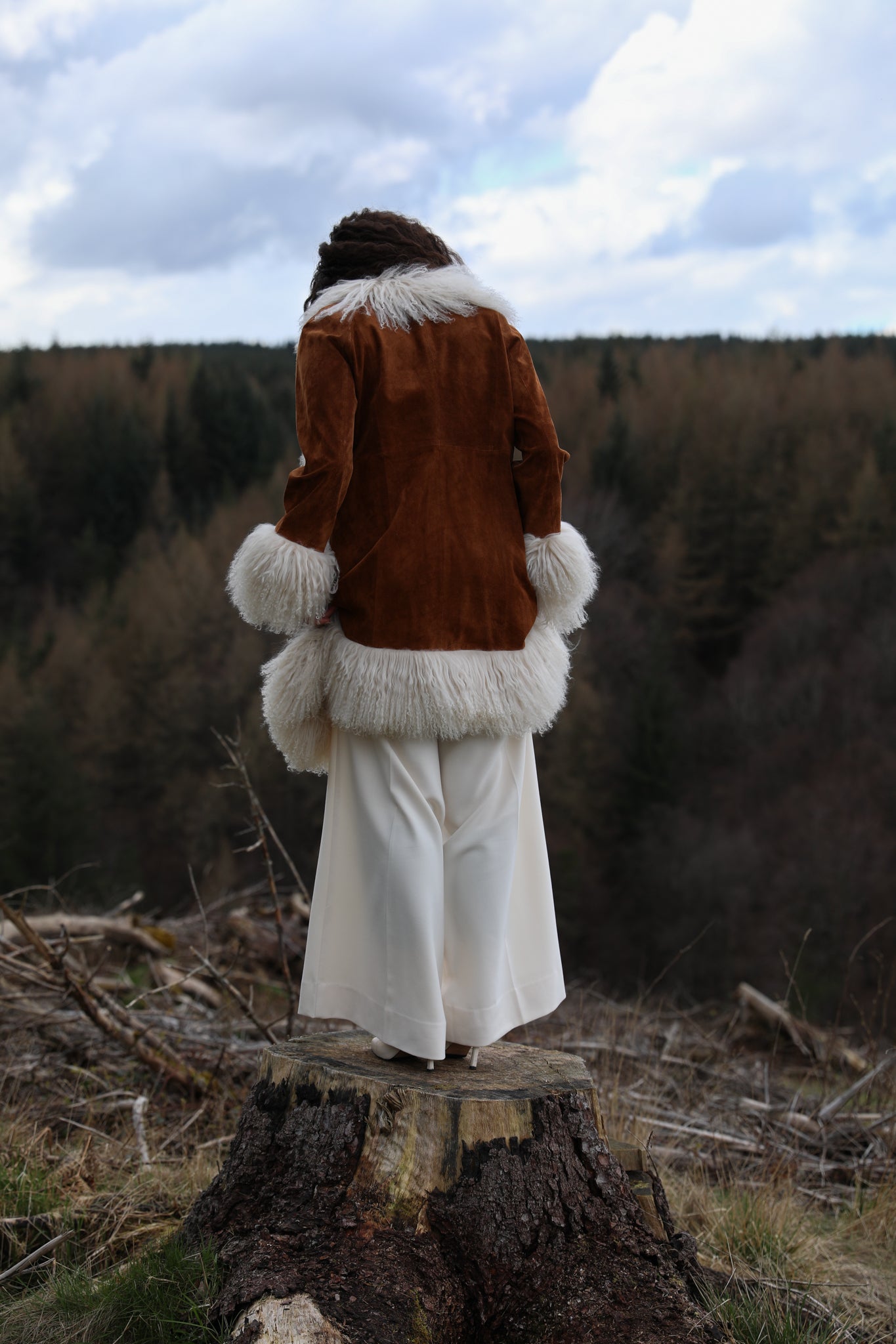 Tan genuine suede afghan penny lane coat mid-length with crew neck, adorned with luxurious ivory Mongolian fur trims by Josephine Jones - exquisite outerwear for timeless style.