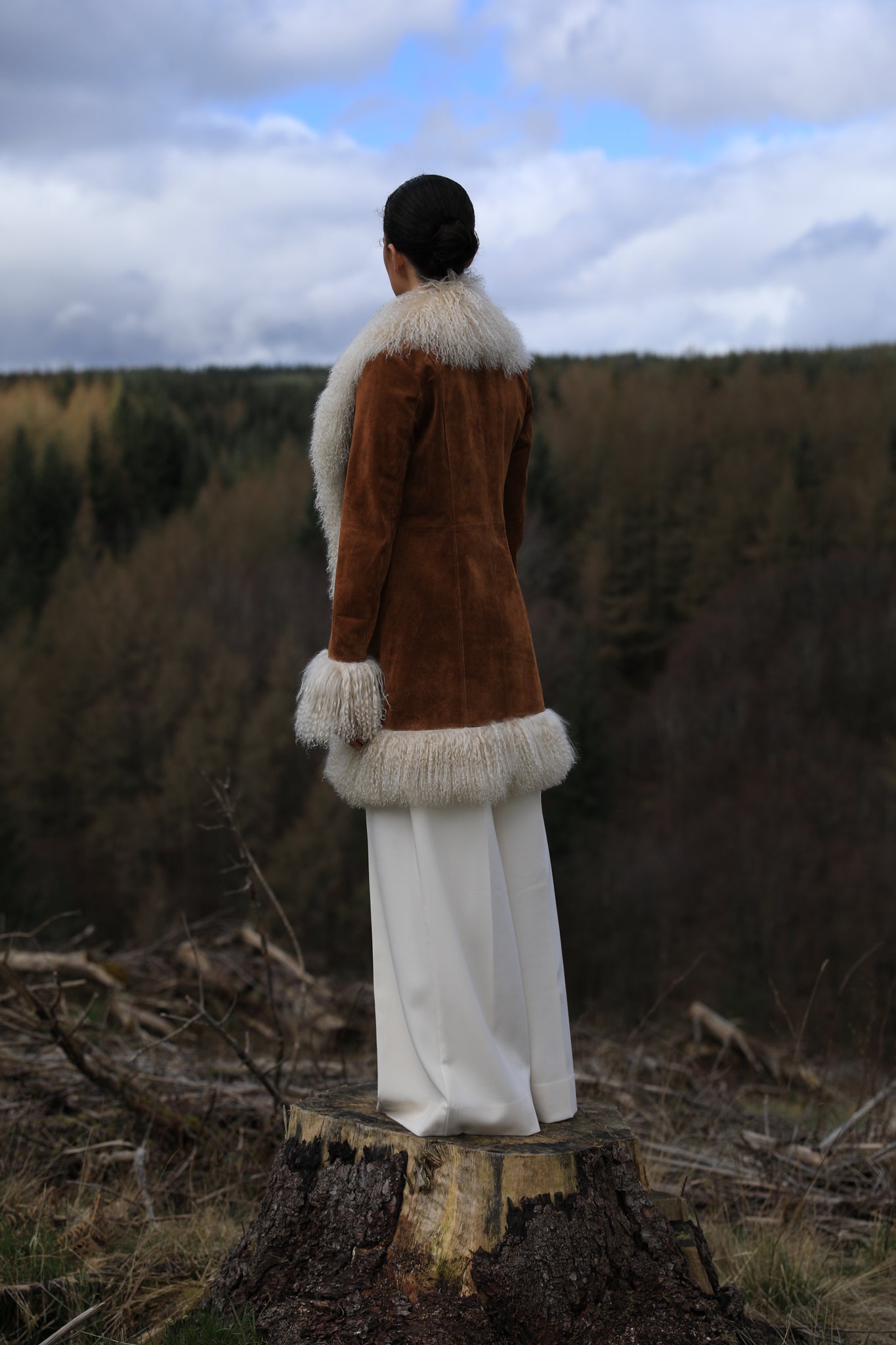 A stylish tan suede midi jacket from Josephine Jones, featuring classic Afghan Penny Lane style with elegant ivory Mongolian fur trims. Perfect for adding a touch of luxury to any outfit.