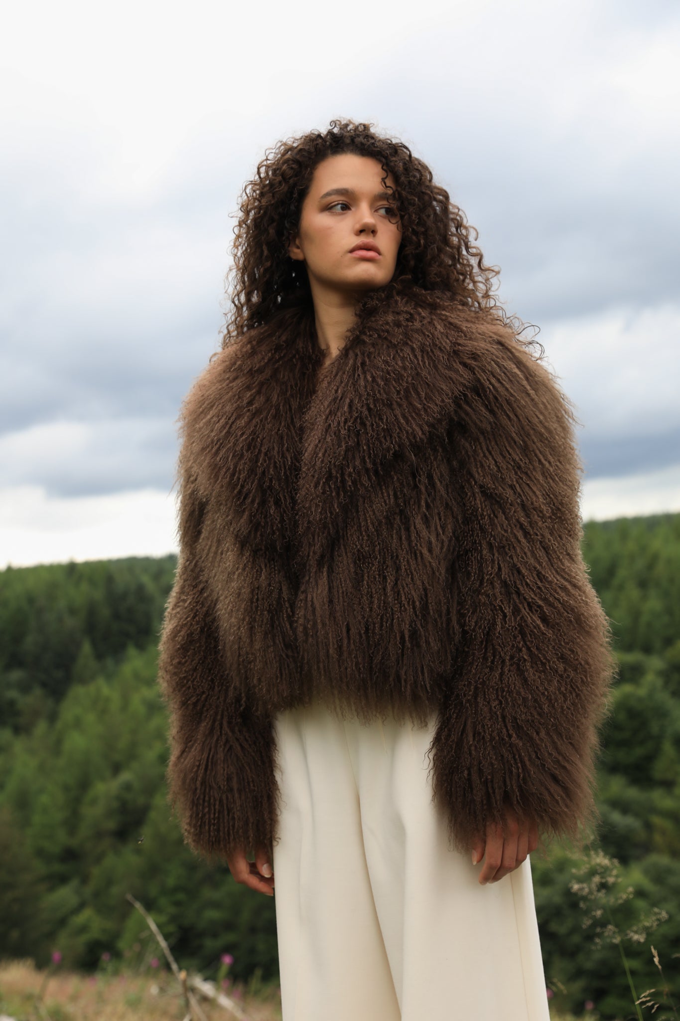 Josephine Jones' signature chocolate-colored Mongolian fur coat, featuring a voluminous collar. A luxurious staple piece perfect for adding warmth and elegance to any ensemble.