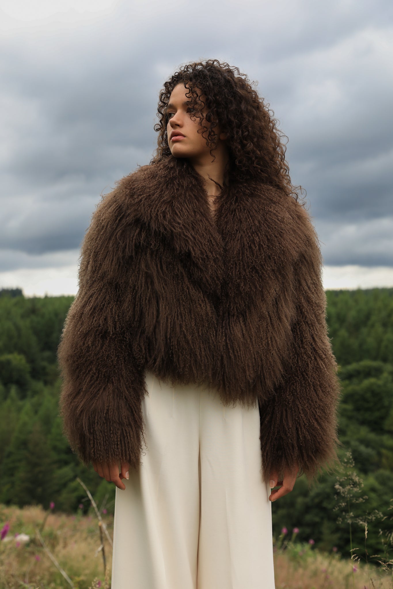 Josephine Jones' signature chocolate-colored Mongolian fur coat, featuring a voluminous collar. A luxurious staple piece perfect for adding warmth and elegance to any ensemble.