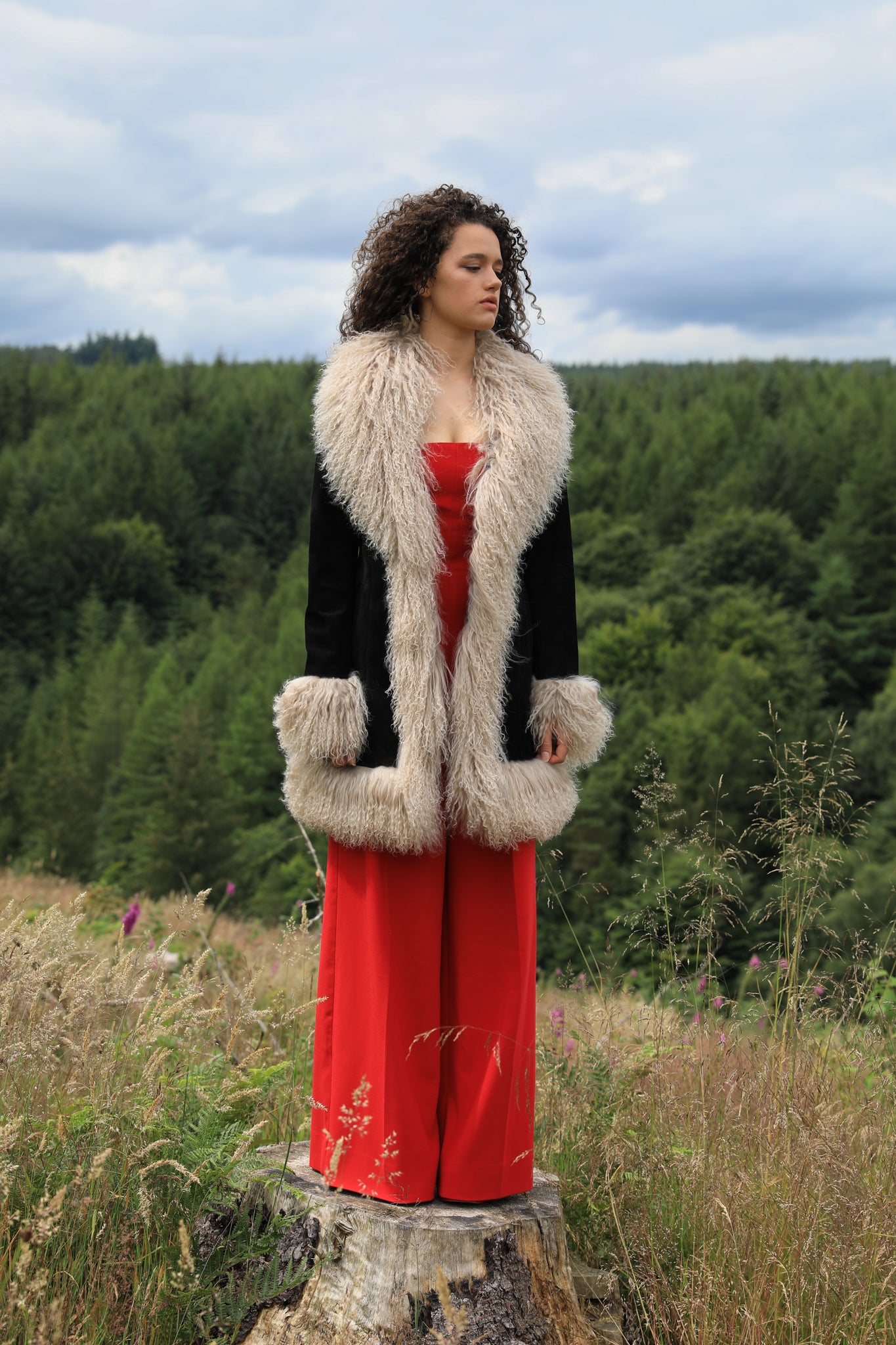 Josephine Jones' timeless black suede midi jacket with beige Mongolian fur trims, exuding classic Afghan Penny Lane style.