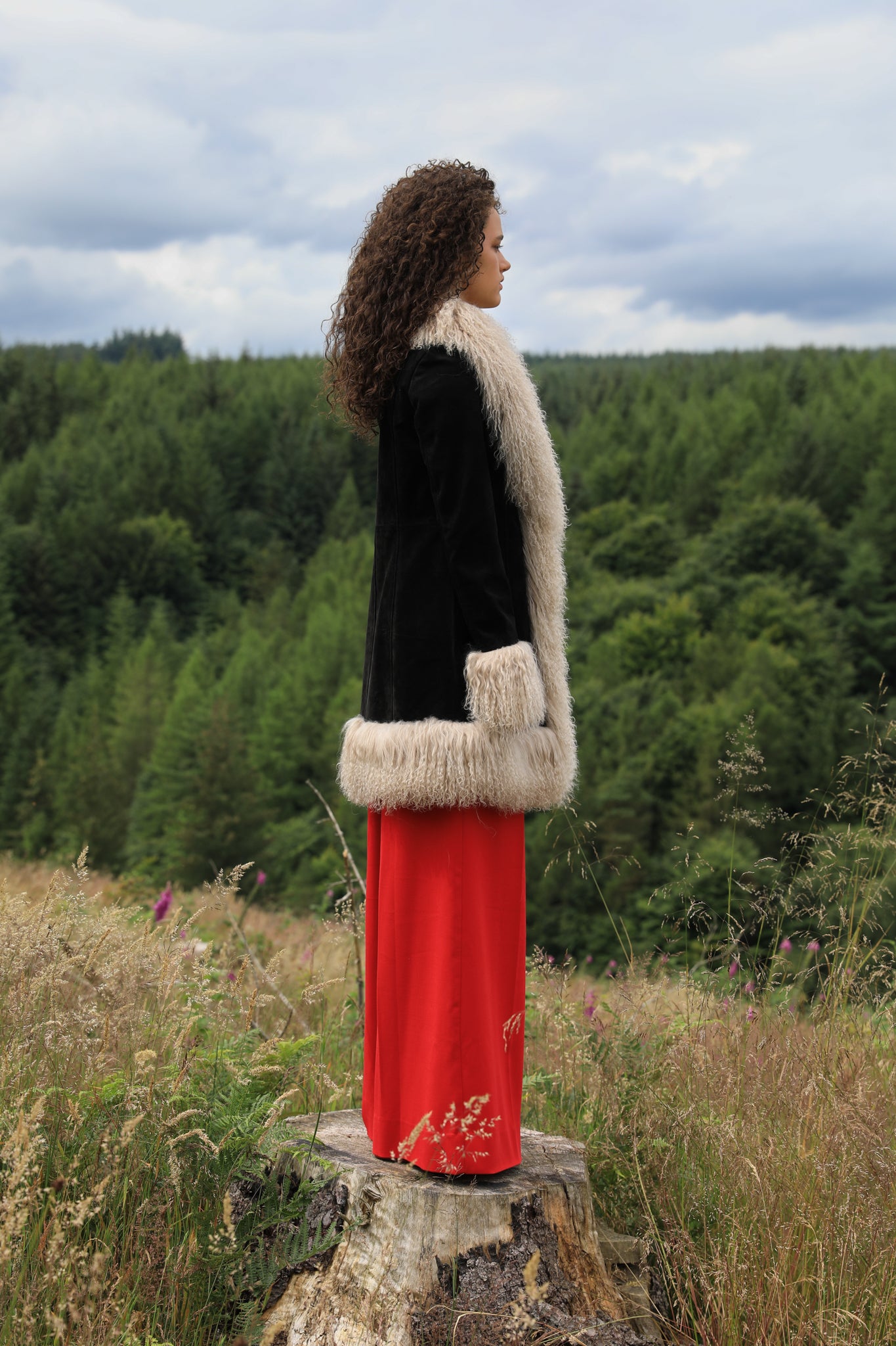 Josephine Jones' timeless black suede midi jacket with beige Mongolian fur trims, exuding classic Afghan Penny Lane style.