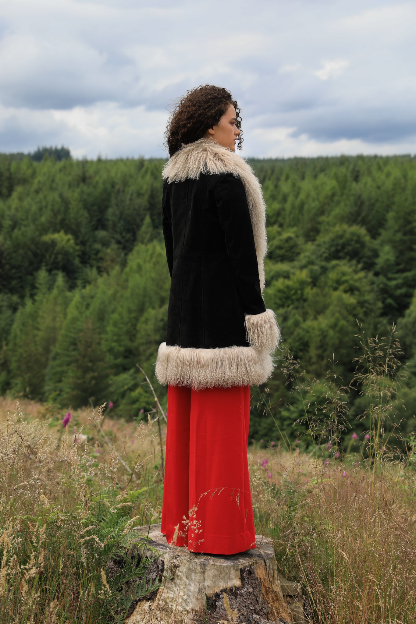 Josephine Jones' timeless black suede midi jacket with beige Mongolian fur trims, exuding classic Afghan Penny Lane style.