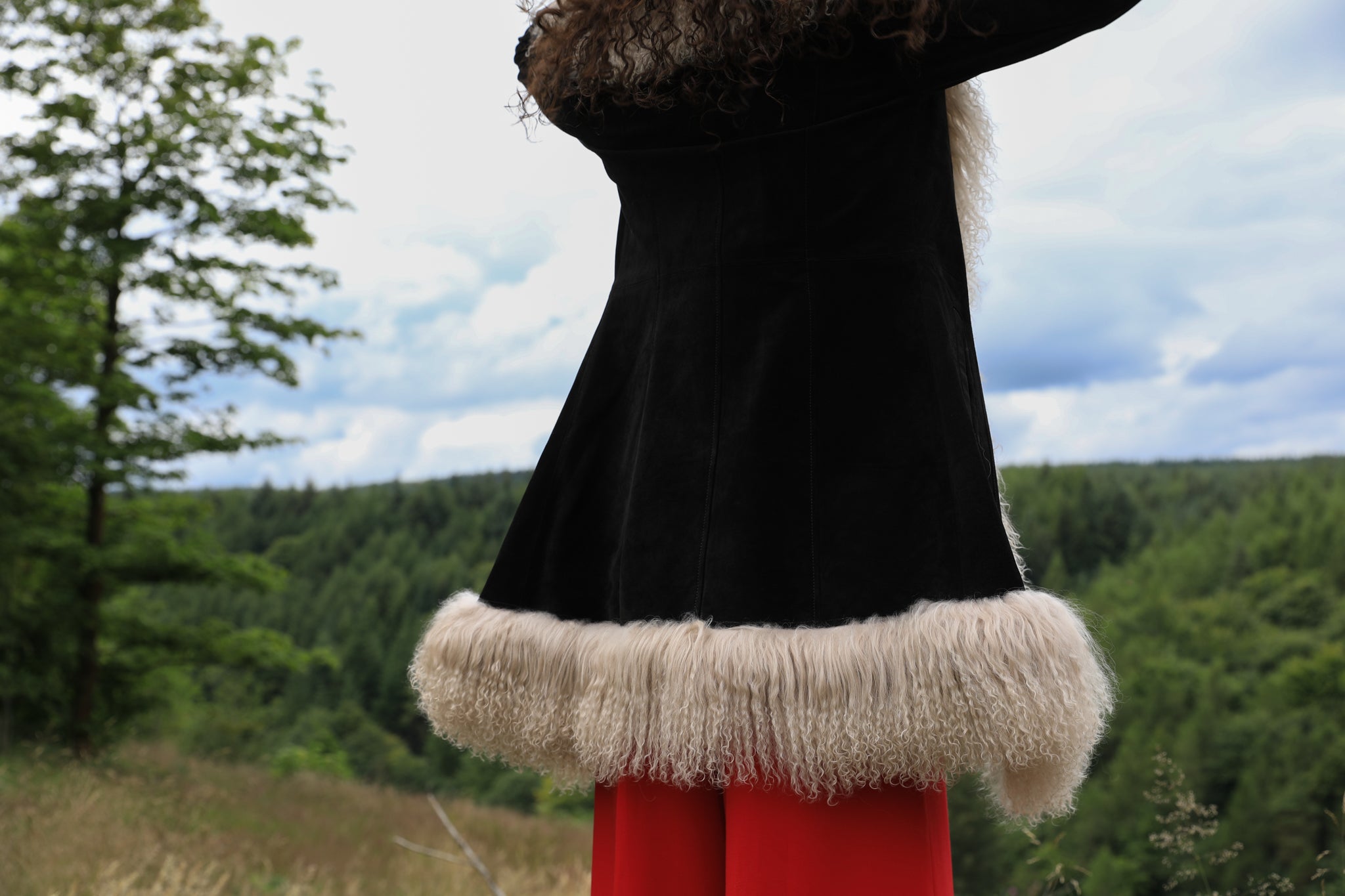 Josephine Jones' timeless black suede midi jacket with beige Mongolian fur trims, exuding classic Afghan Penny Lane style.