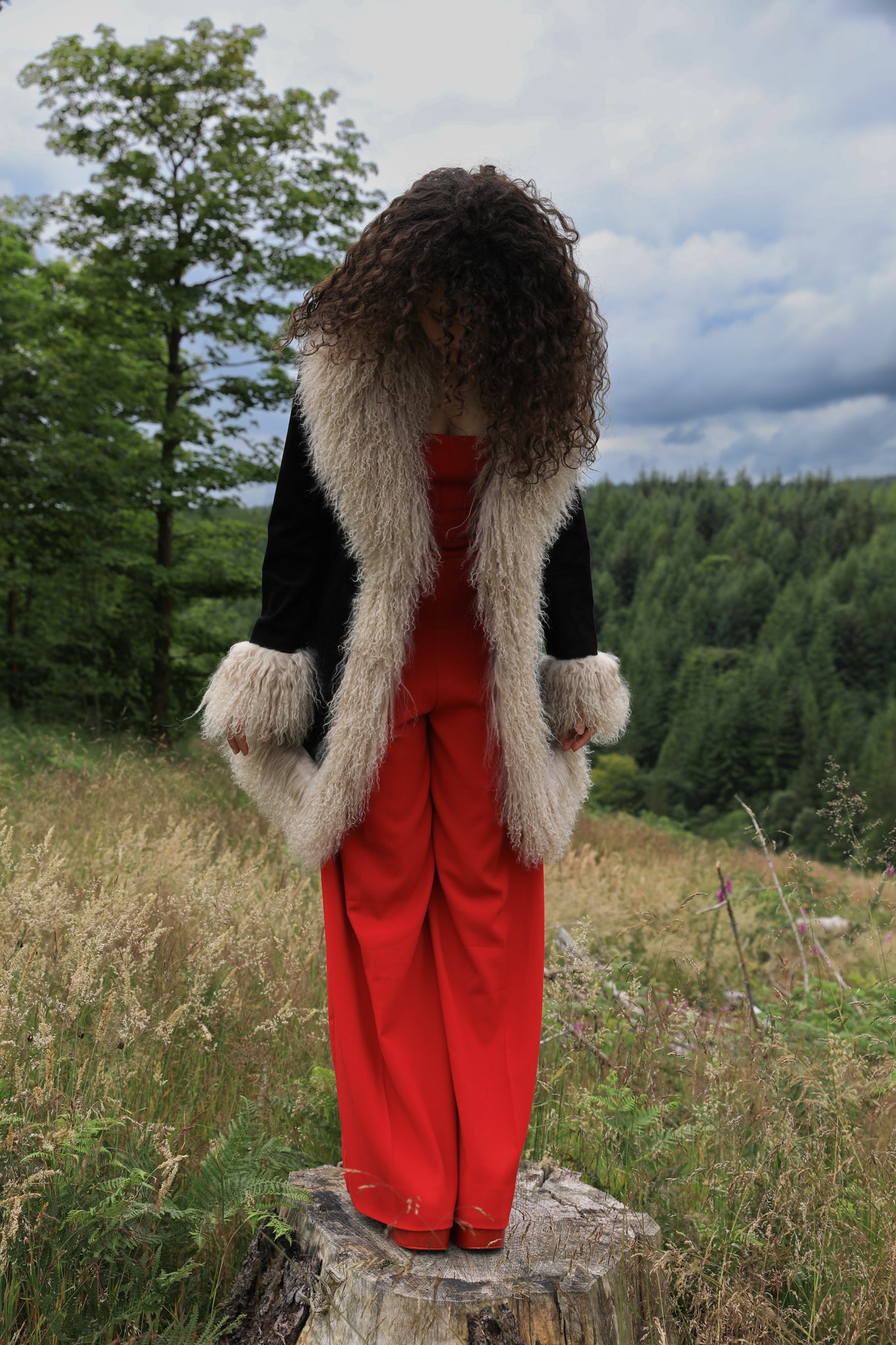 Josephine Jones' timeless black suede midi jacket with beige Mongolian fur trims, exuding classic Afghan Penny Lane style.