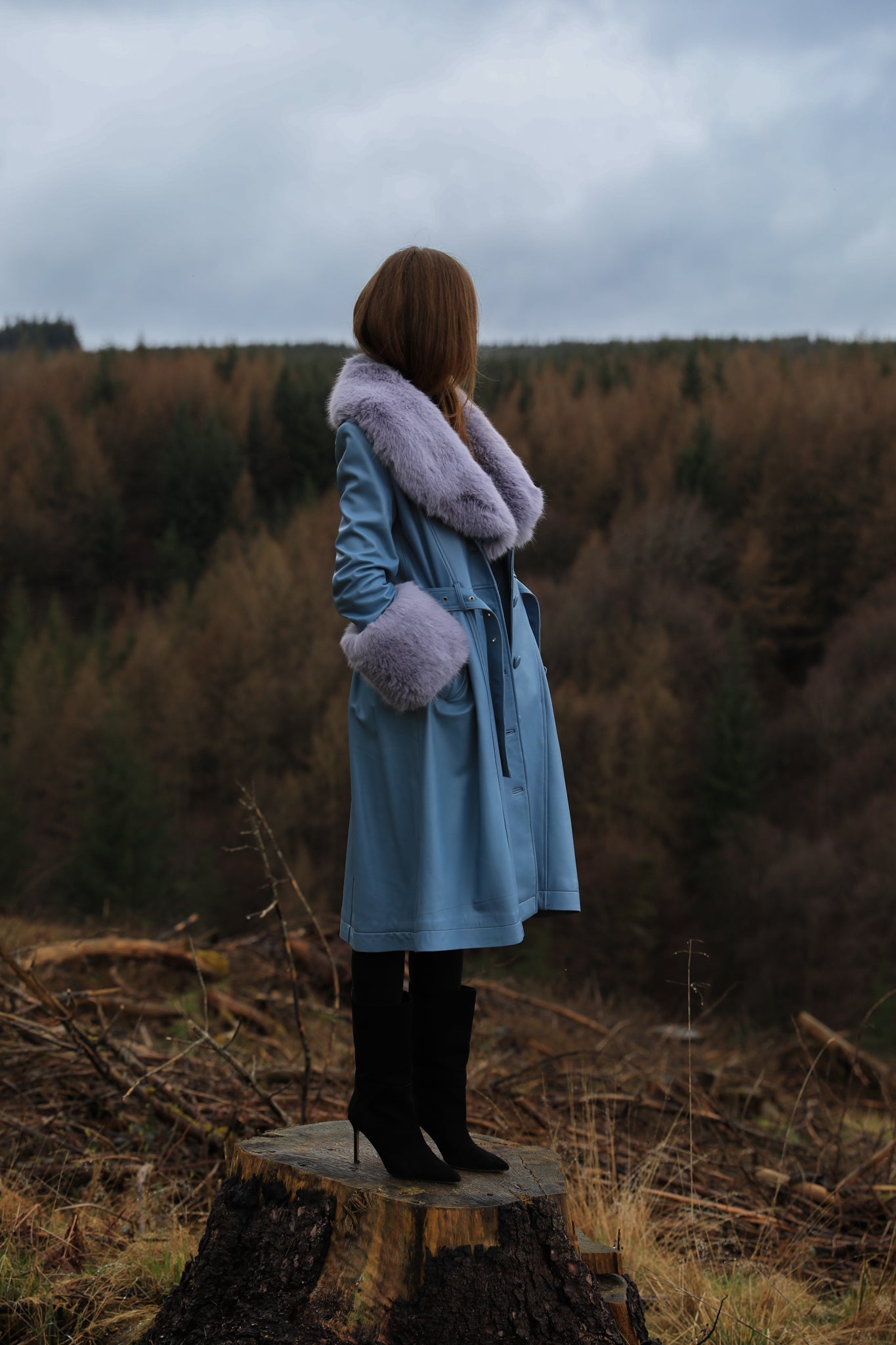 Genuine leather blue trench coat with lavender faux fur collar and cuffs, a stylish creation from Josephine Jones. Perfect for adding a touch of elegance and warmth to any ensemble.