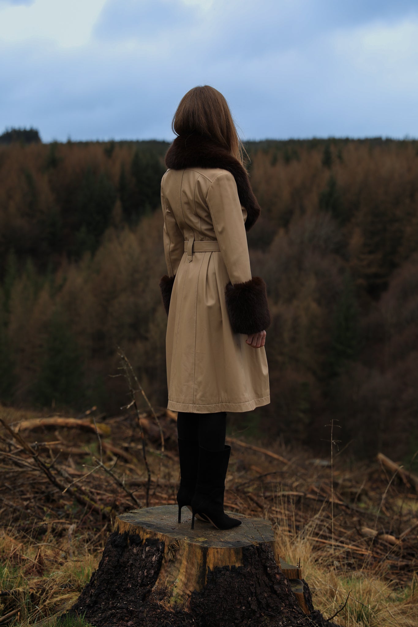 A sophisticated genuine leather beige trench coat from Josephine Jones, featuring a rich chocolate faux fur collar and cuffs. Elevate your style with this luxurious outerwear piece.