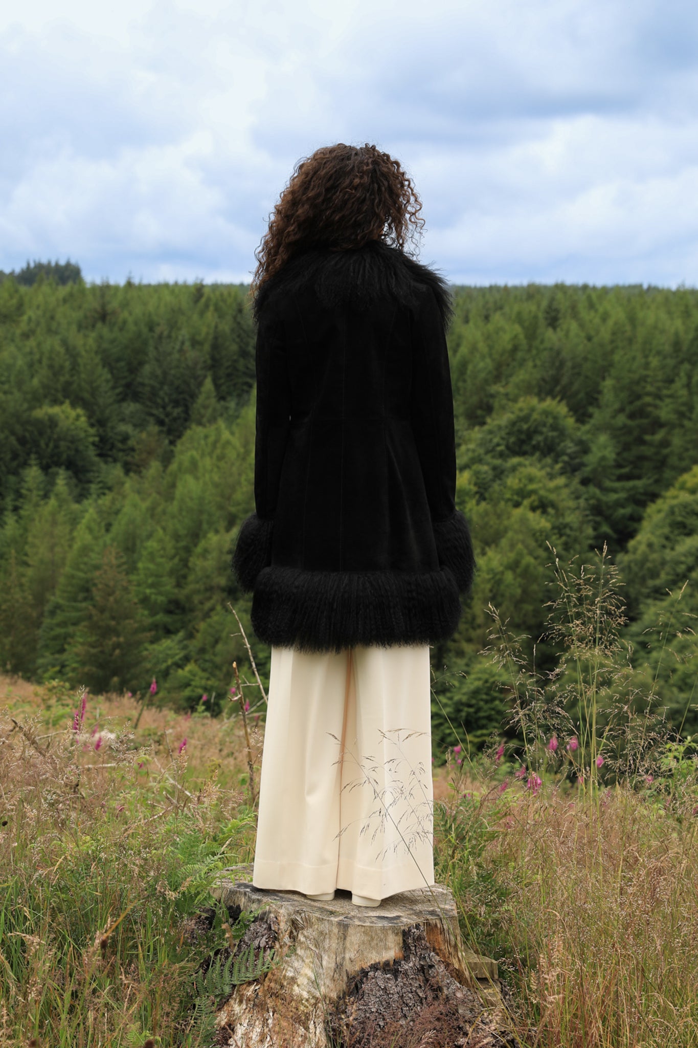 A stylish black suede midi jacket with black Mongolian fur trims, reminiscent of the iconic Penny Lane style. Crafted by Josephine Jones, this genuine suede coat exudes timeless elegance and sophistication, perfect for any fashion-forward wardrobe.