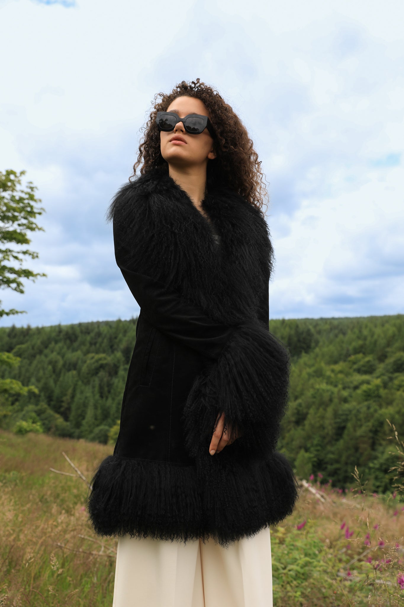 A stylish black suede midi jacket with black Mongolian fur trims, reminiscent of the iconic Penny Lane style. Crafted by Josephine Jones, this genuine suede coat exudes timeless elegance and sophistication, perfect for any fashion-forward wardrobe.