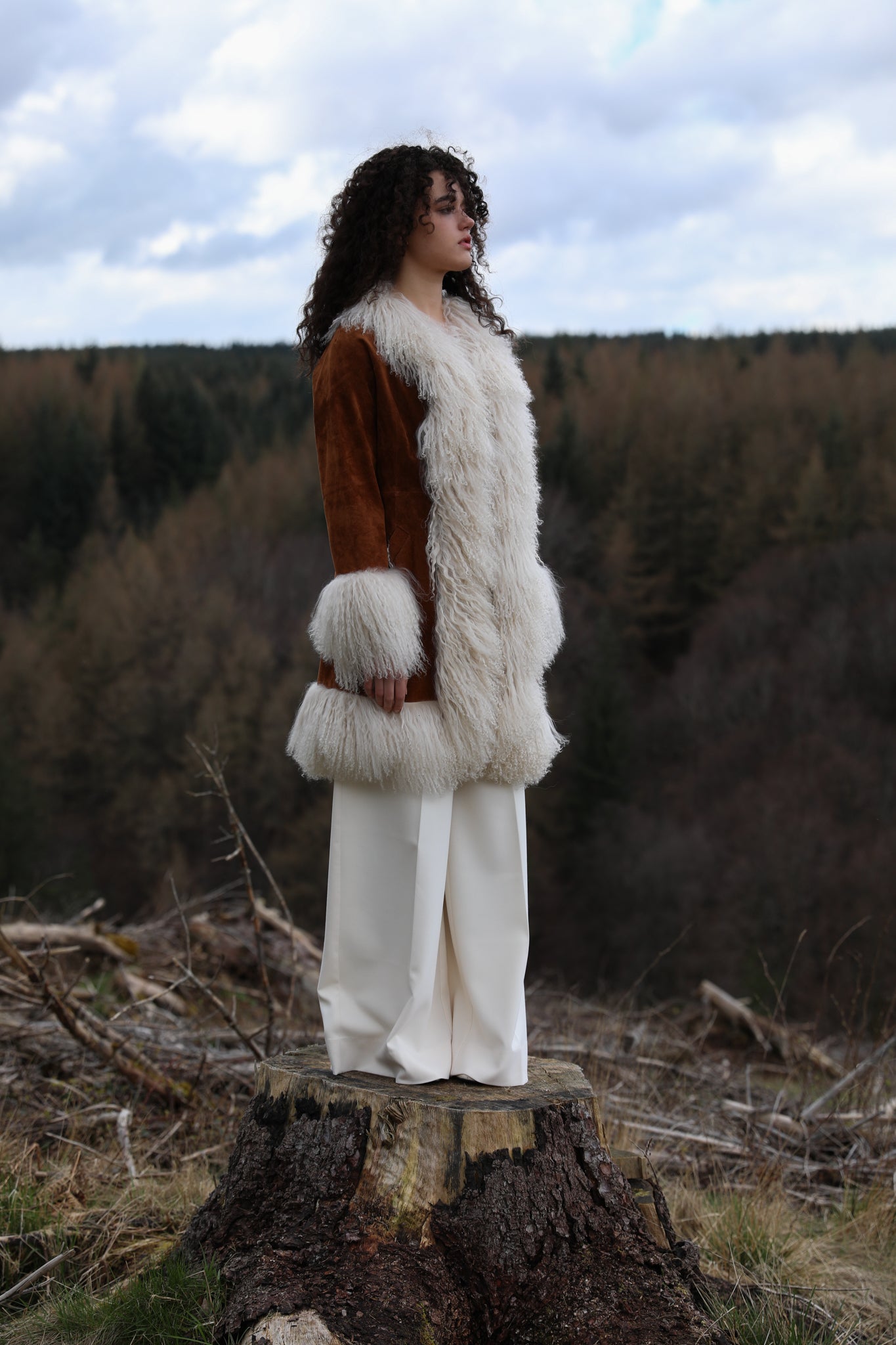 Tan genuine suede afghan penny lane coat mid-length with crew neck, adorned with luxurious ivory Mongolian fur trims by Josephine Jones - exquisite outerwear for timeless style.