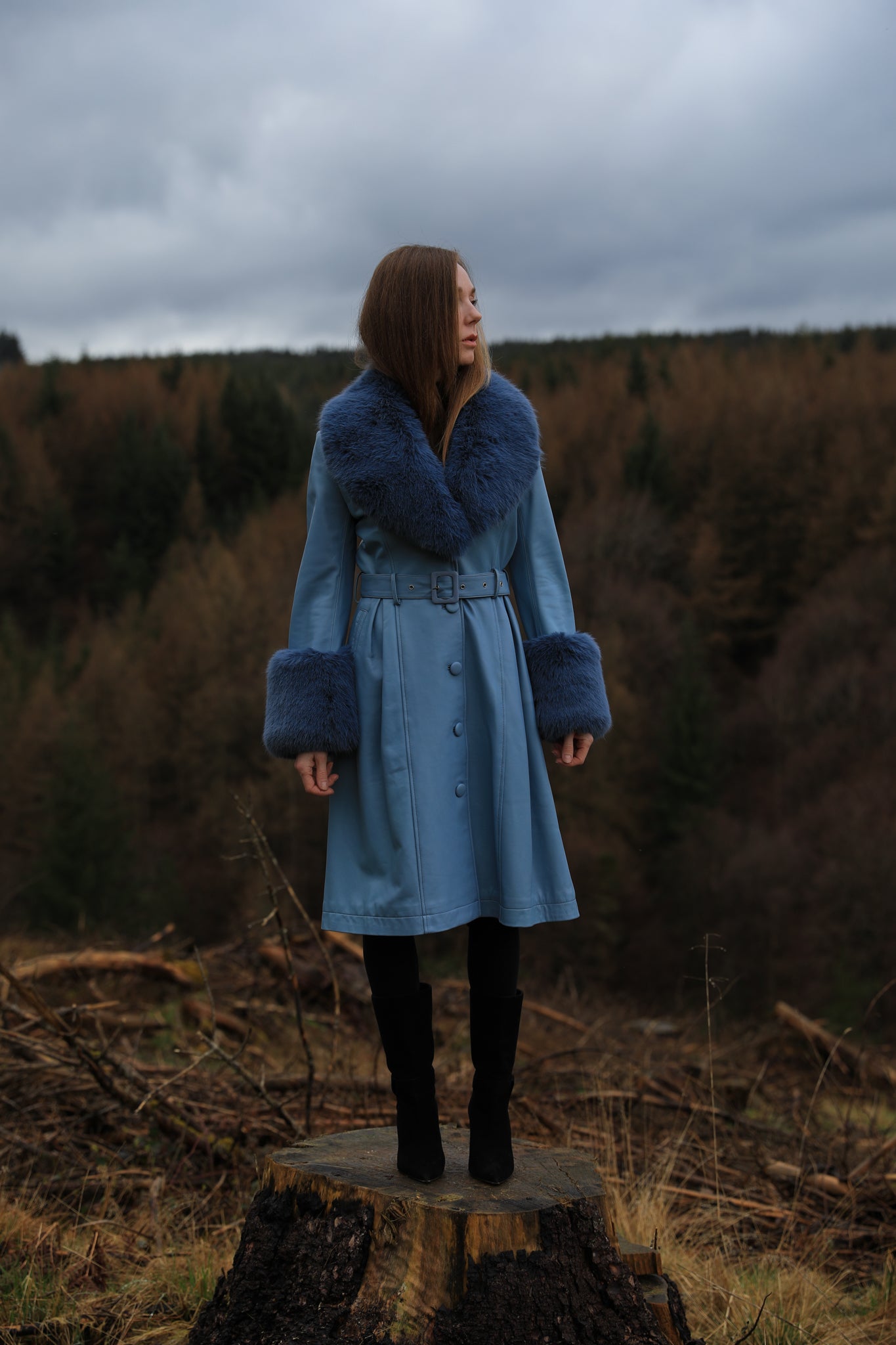  A stylish azure trench coat crafted from genuine leather, featuring a faux fur collar and cuffs, designed by Josephine Jones. Stand out in sophistication with this luxurious outerwear piece.