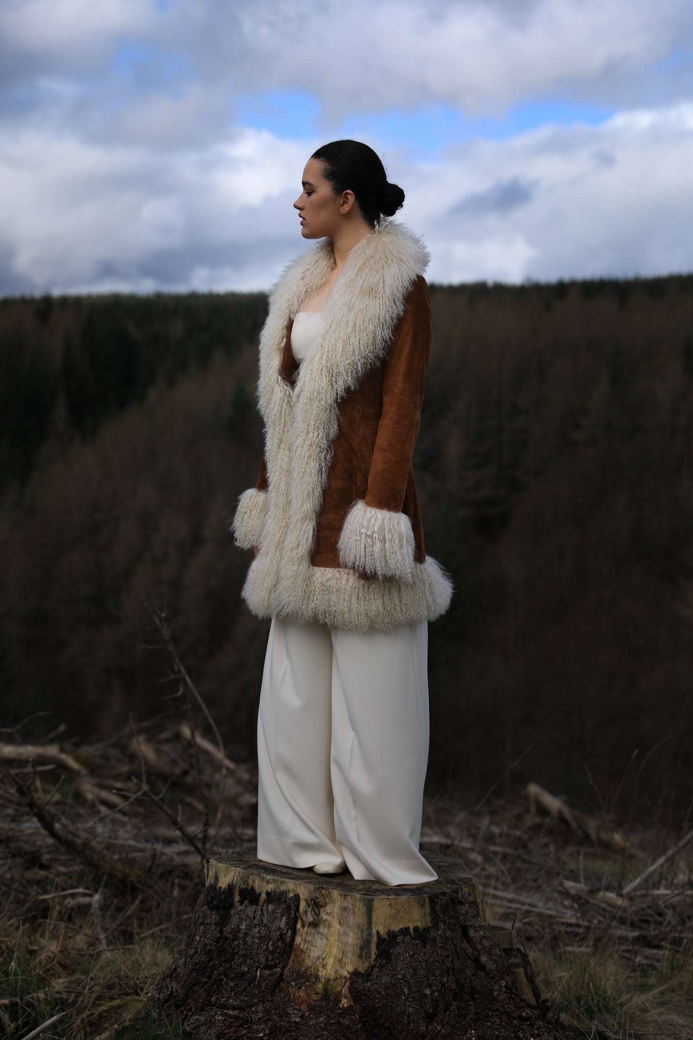 A stylish tan suede midi jacket from Josephine Jones, featuring classic Afghan Penny Lane style with elegant ivory Mongolian fur trims. Perfect for adding a touch of luxury to any outfit.