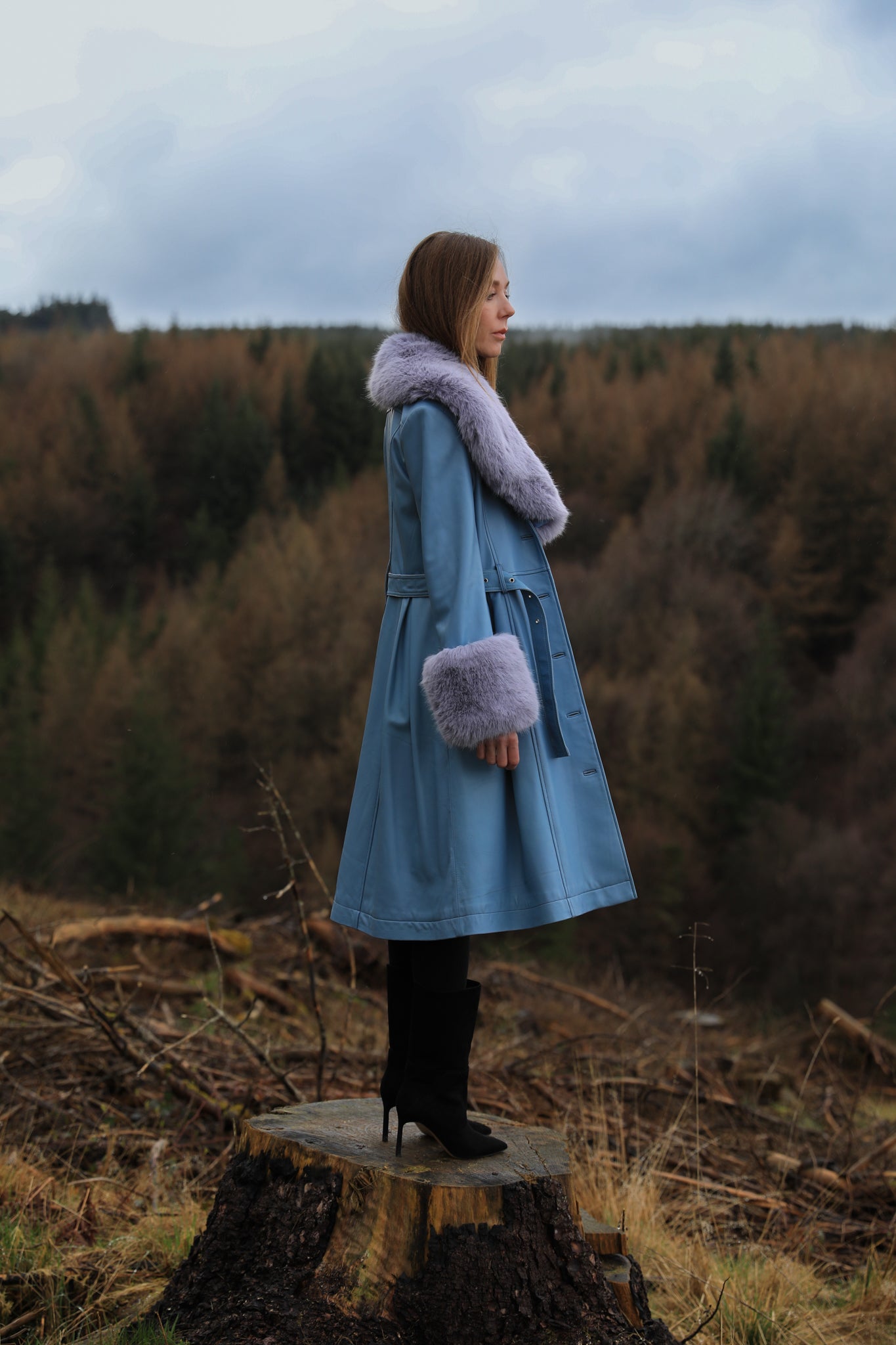 Genuine leather blue trench coat with lavender faux fur collar and cuffs, a stylish creation from Josephine Jones. Perfect for adding a touch of elegance and warmth to any ensemble.