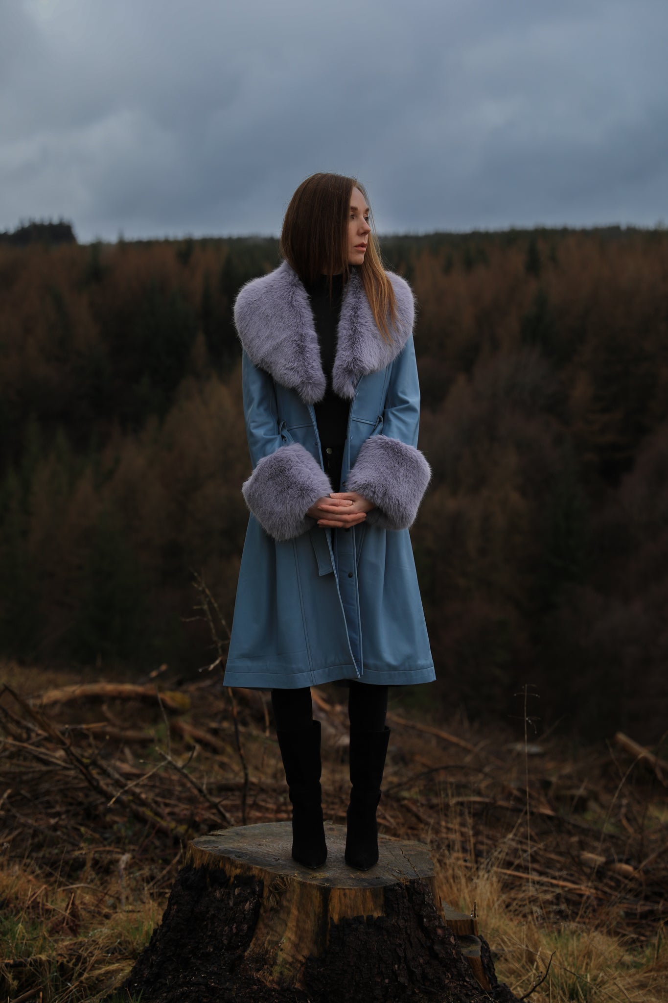 Genuine leather blue trench coat with lavender faux fur collar and cuffs, a stylish creation from Josephine Jones. Perfect for adding a touch of elegance and warmth to any ensemble.