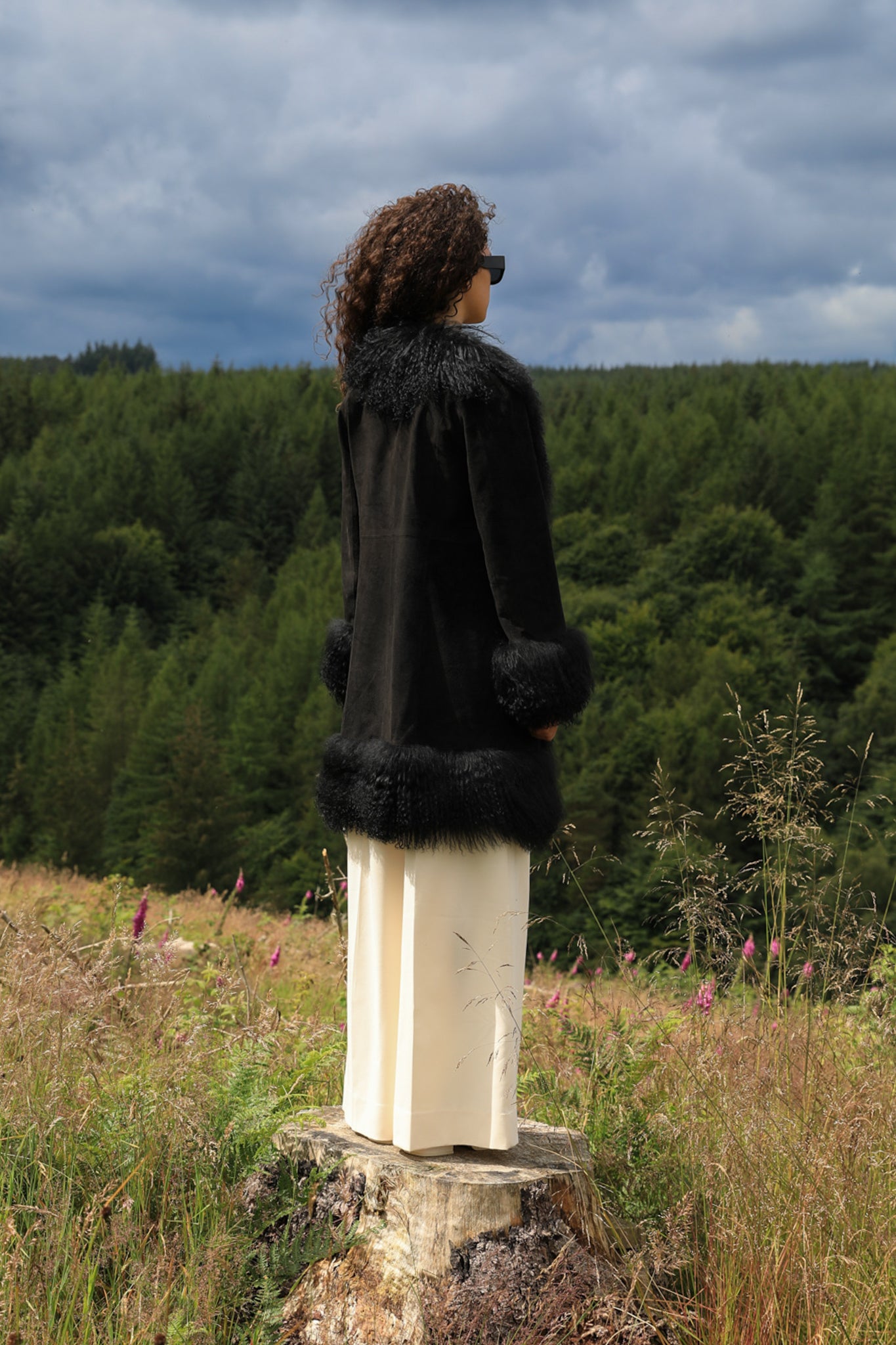 Black genuine suede Afghan Penny Lane coat with mid-length silhouette and crew neck, designed by Josephine Jones. Luxurious outerwear perfect for stylish winter ensembles.