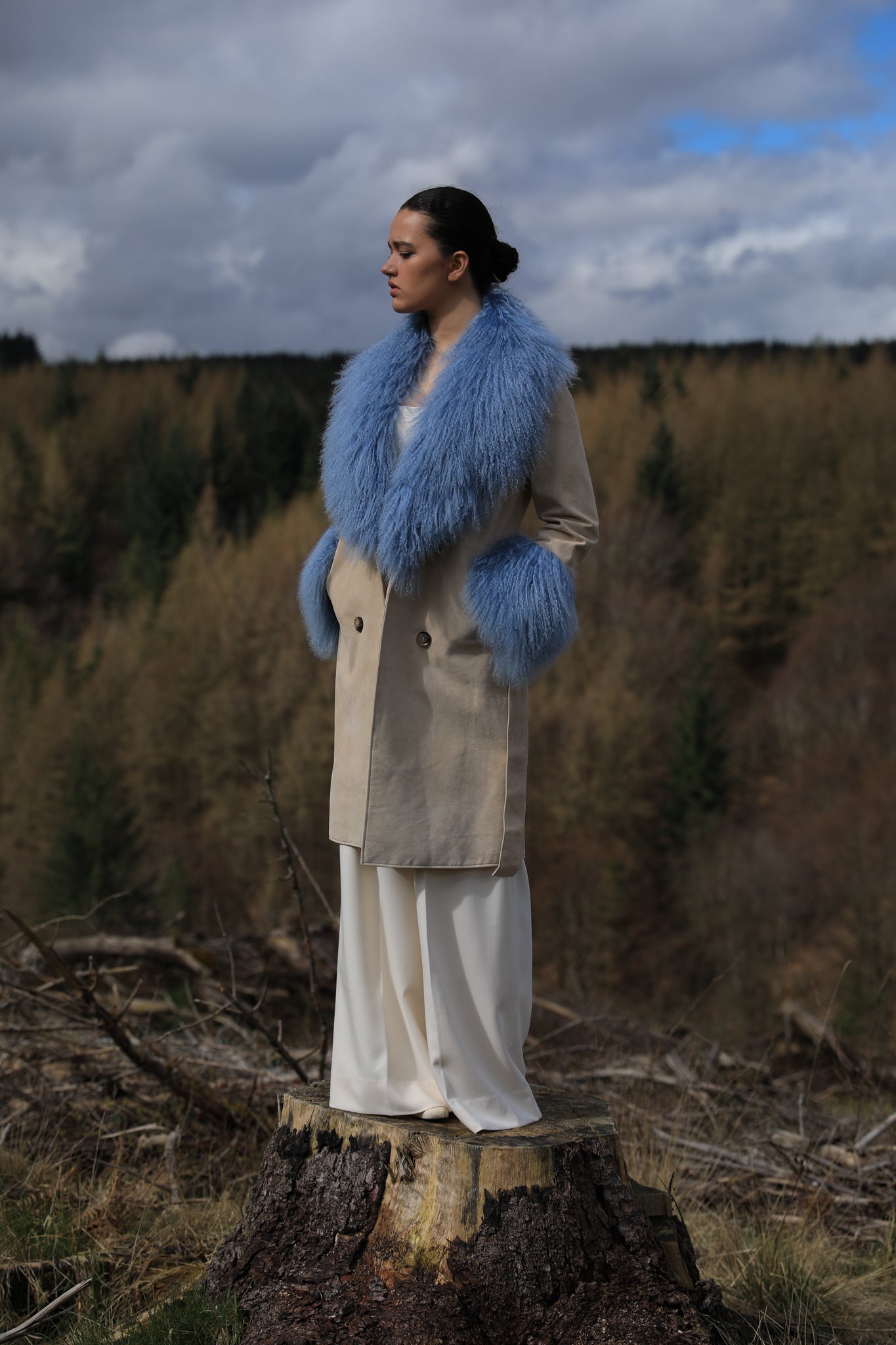 Ivory genuine suede trench wrap coat with cornflower blue Mongolian collar and cuffs by Josephine Jones. This luxurious coat exudes elegance and style, perfect for making a statement while staying warm and chic.