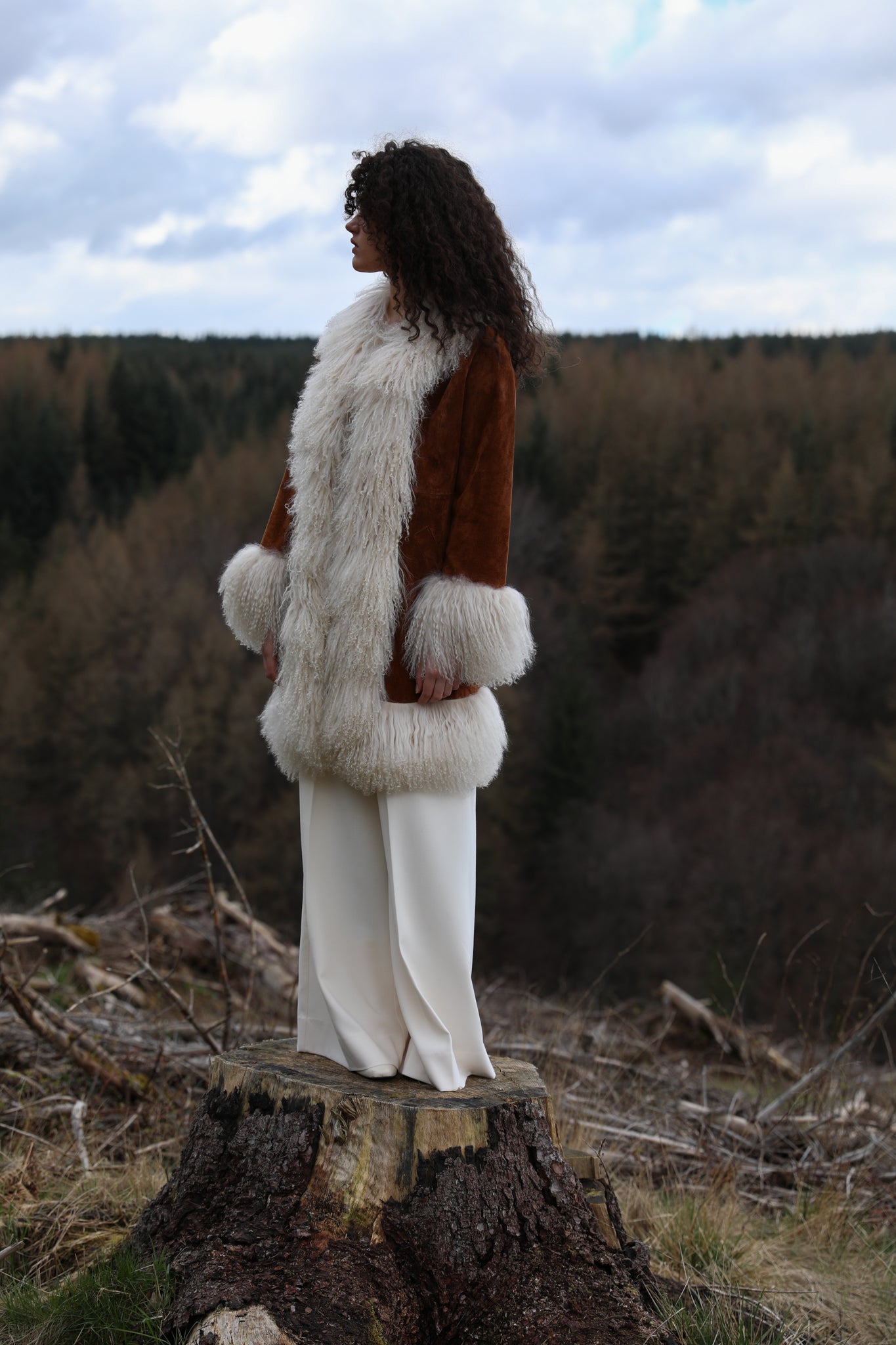 Tan genuine suede afghan penny lane coat mid-length with crew neck, adorned with luxurious ivory Mongolian fur trims by Josephine Jones - exquisite outerwear for timeless style.