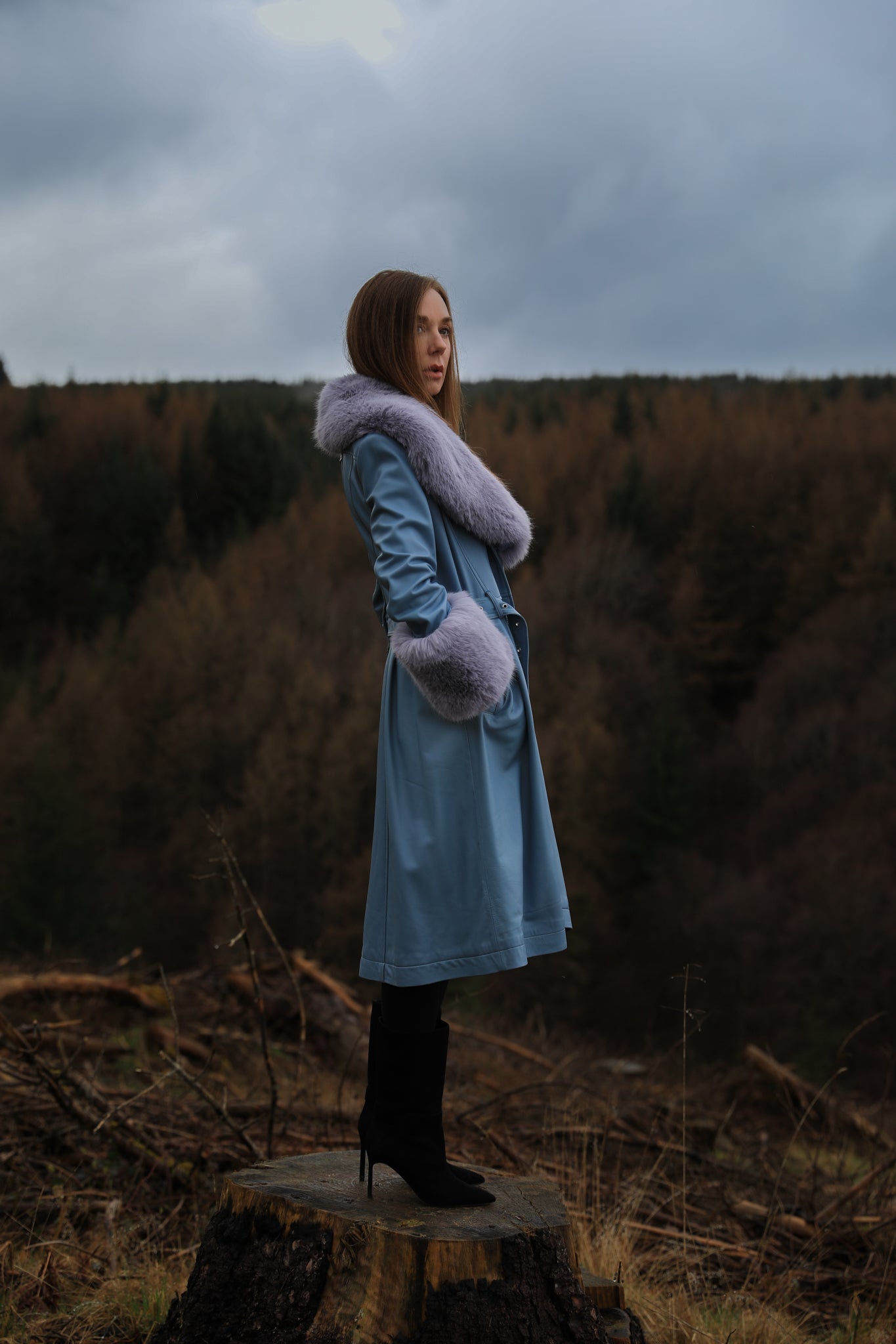 Genuine leather blue trench coat with lavender faux fur collar and cuffs, a stylish creation from Josephine Jones. Perfect for adding a touch of elegance and warmth to any ensemble.