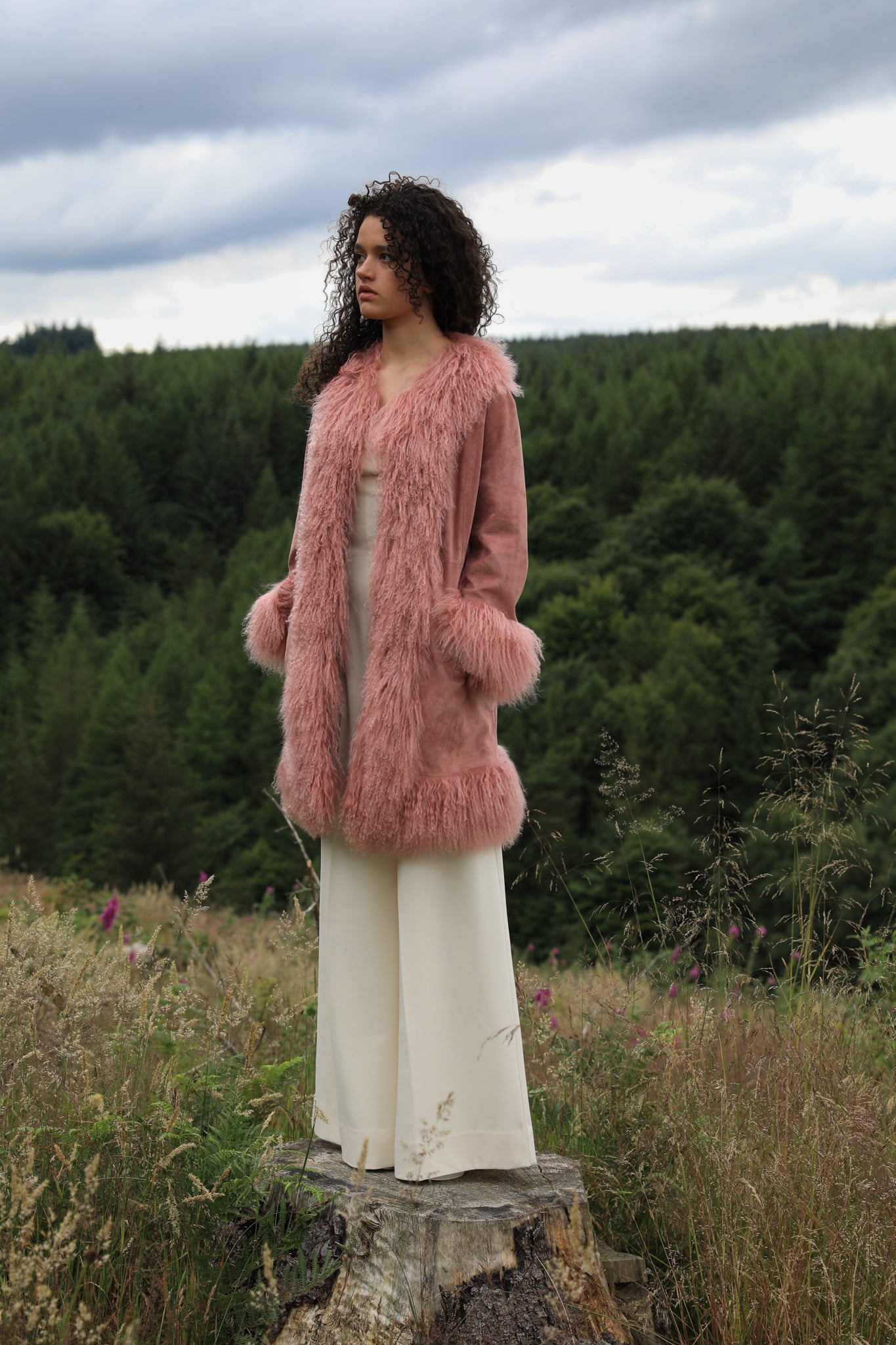 Blush genuine suede Afghan Penny Lane coat with mid-length design and crew neck, crafted by Josephine Jones.' This alt text provides a concise description of the coat, including its color, material, style, and designer, ensuring accessibility for visually impaired users.