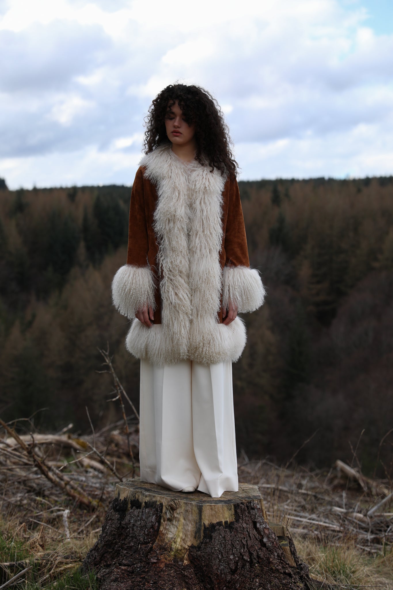 Tan genuine suede afghan penny lane coat mid-length with crew neck, adorned with luxurious ivory Mongolian fur trims by Josephine Jones - exquisite outerwear for timeless style.