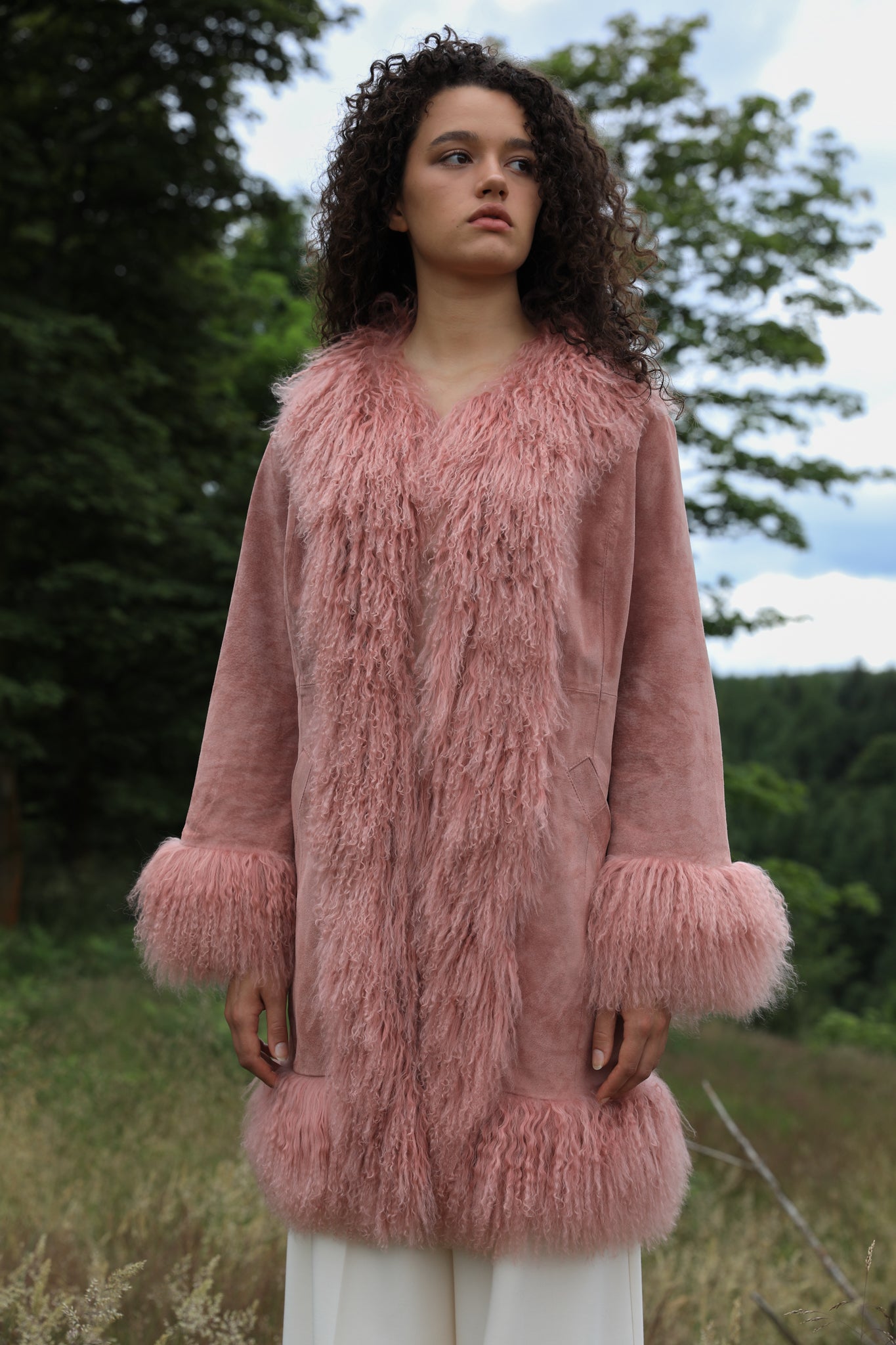 Blush genuine suede Afghan Penny Lane coat with mid-length design and crew neck, crafted by Josephine Jones.' This alt text provides a concise description of the coat, including its color, material, style, and designer, ensuring accessibility for visually impaired users.