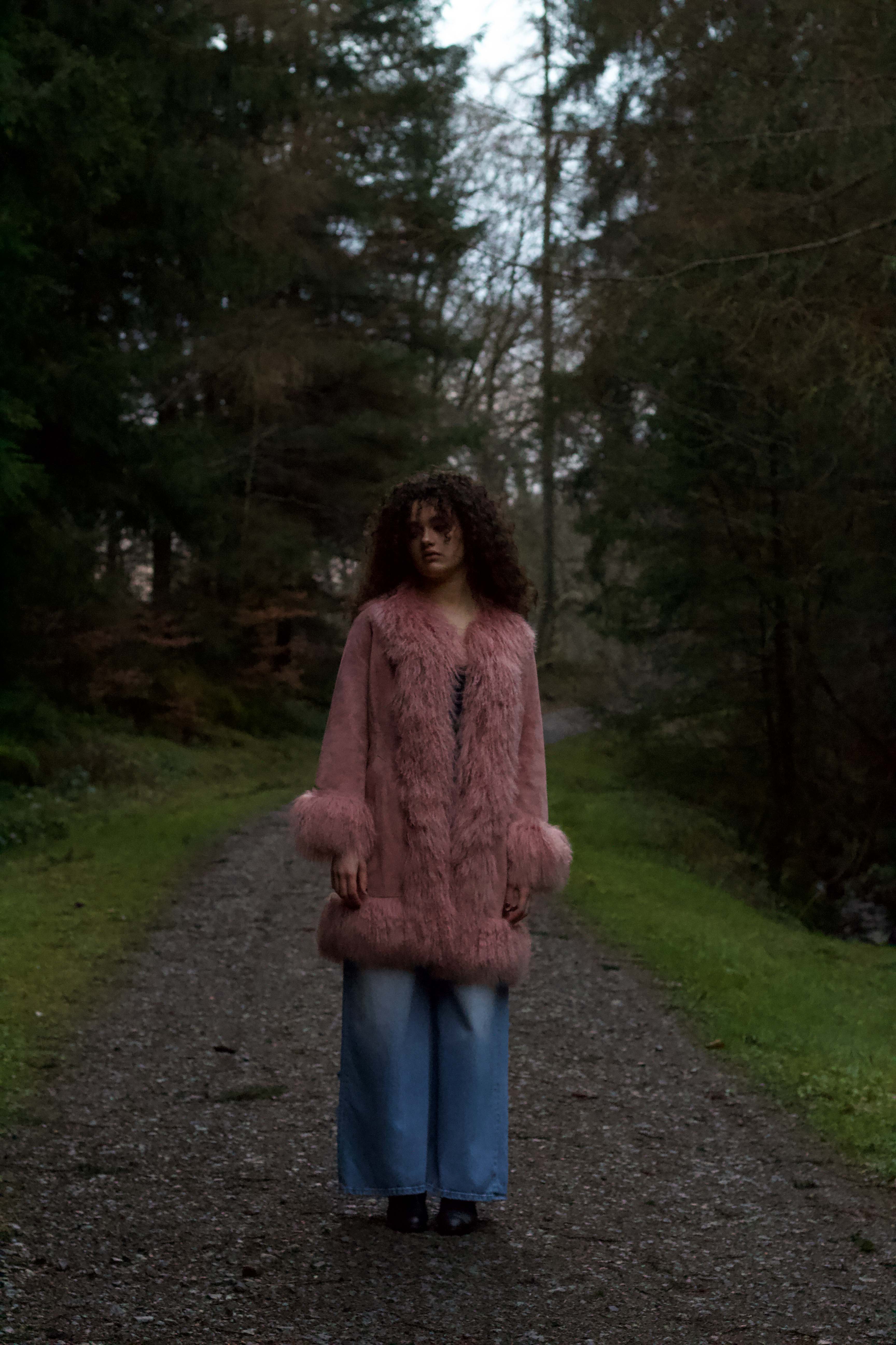 Blush genuine suede Afghan Penny Lane coat with mid-length design and crew neck, crafted by Josephine Jones.' This alt text provides a concise description of the coat, including its color, material, style, and designer, ensuring accessibility for visually impaired users.