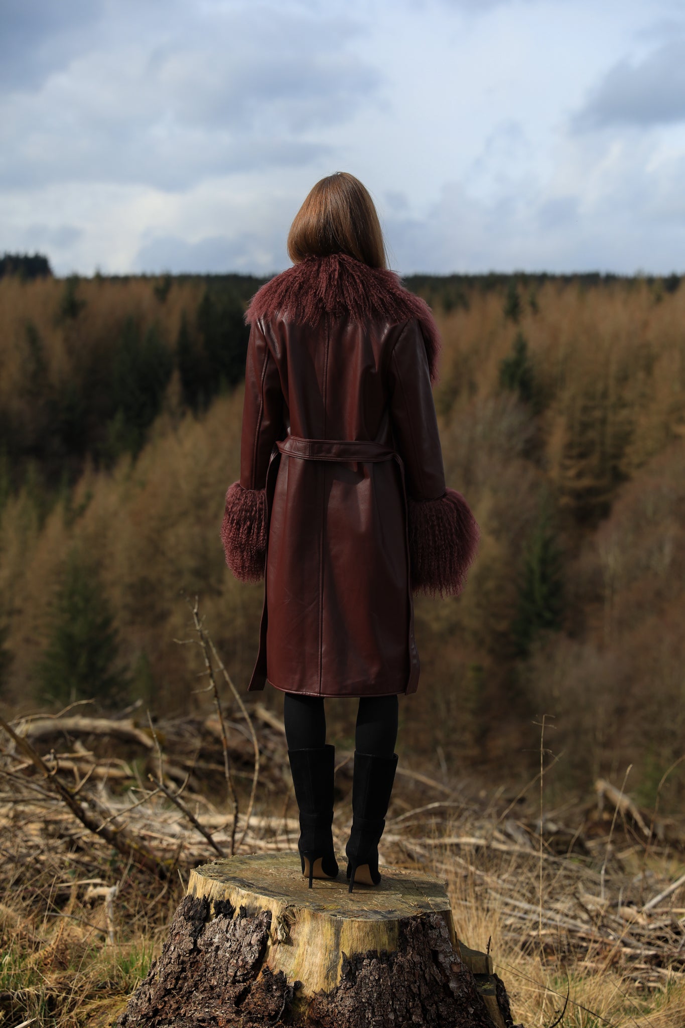 Burgundy genuine leather trench wrap coat with Mongolian collar and cuffs, designed by Josephine Jones. Luxurious outerwear exuding elegance and style