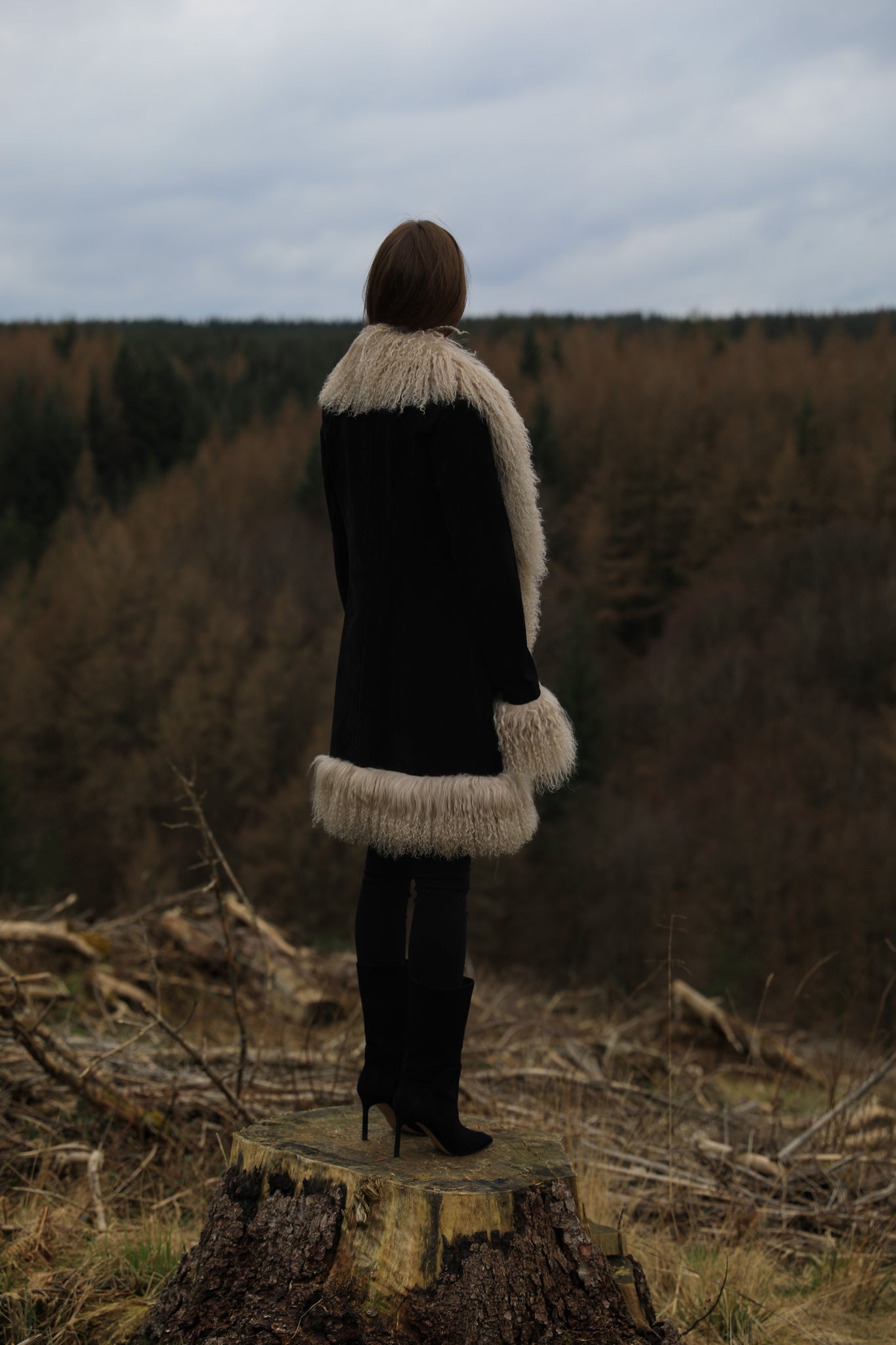 Josephine Jones' timeless black suede midi jacket with beige Mongolian fur trims, exuding classic Afghan Penny Lane style.