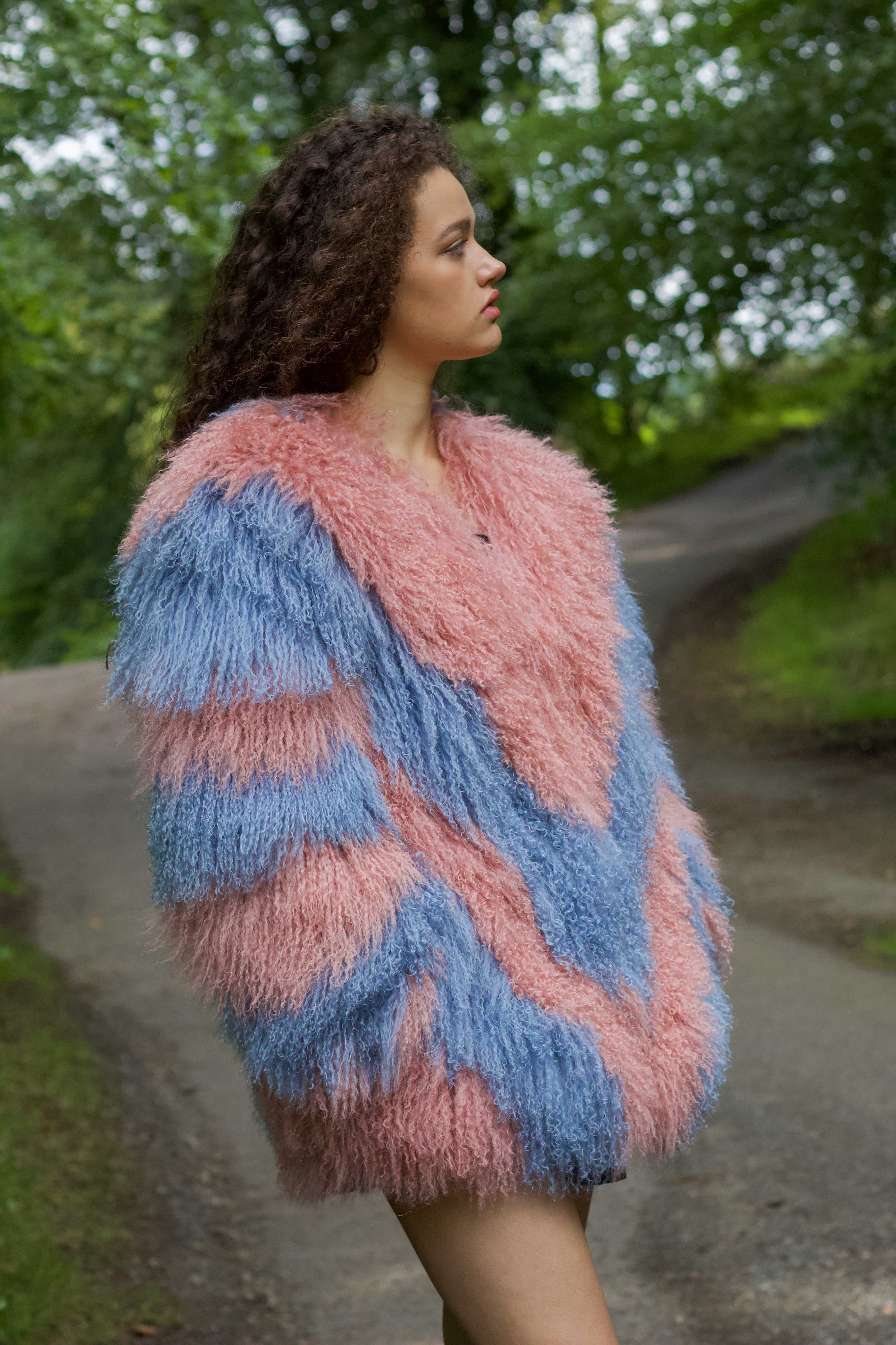 Olivia in Blush: A stunning mid-length Mongolian fur coat adorned with blush and cornflower blue zigzags, the epitome of winter luxury.